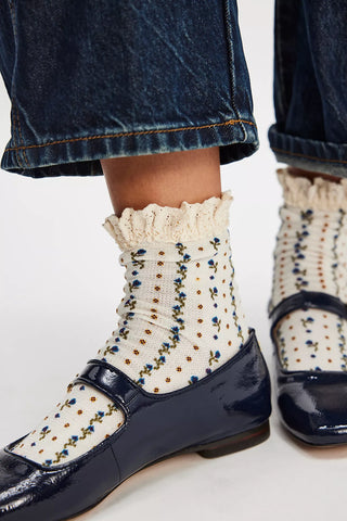 Navy shoes with white polka dot socks on a light background