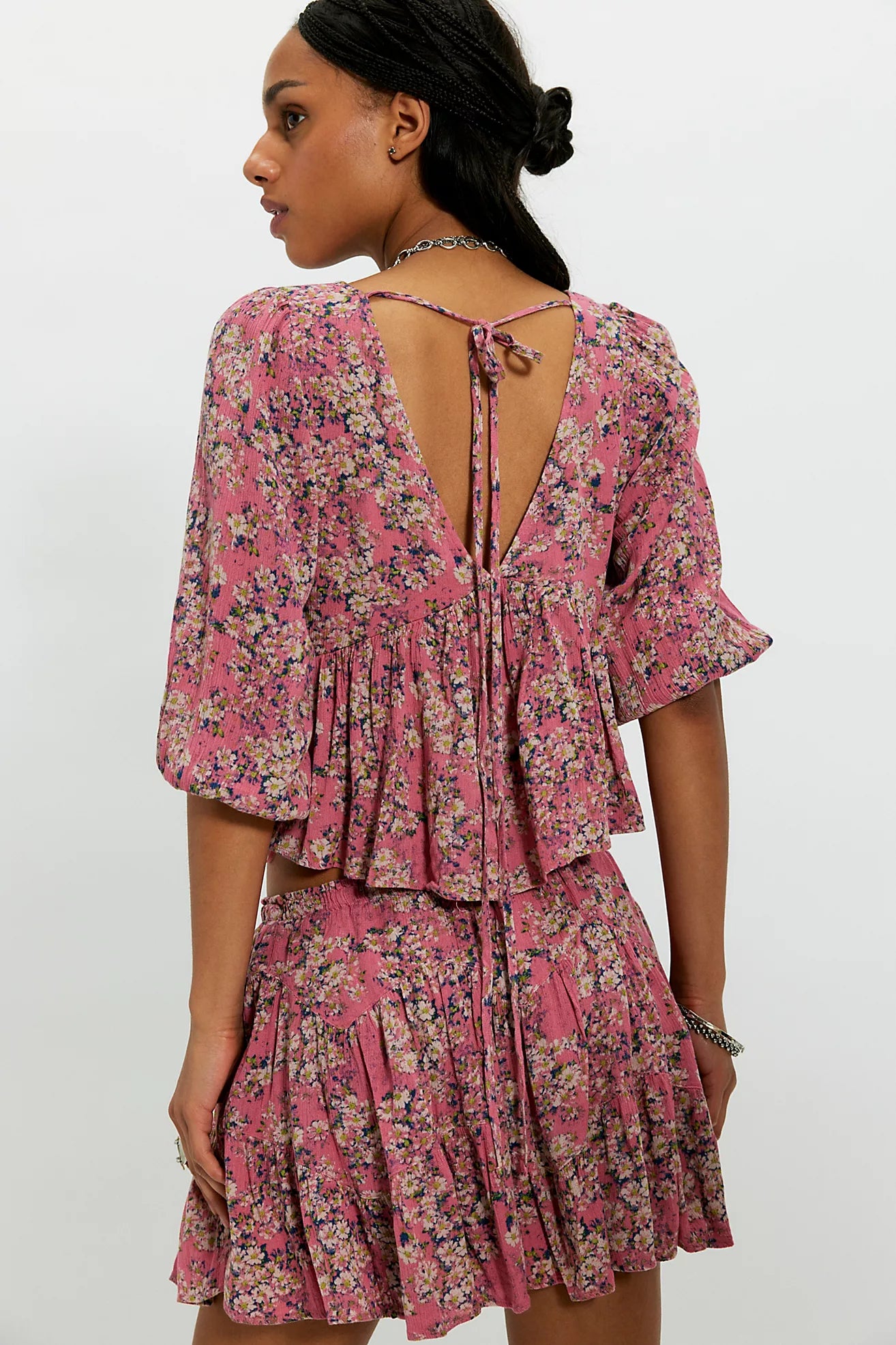 Woman wearing a pink floral dress with a white background