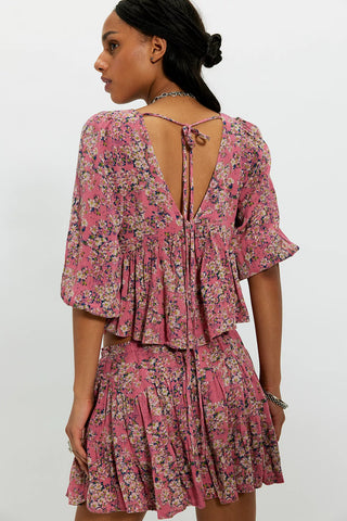 Woman wearing a pink floral dress with a white background