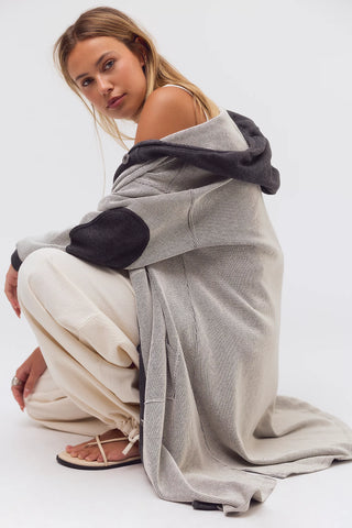 Woman wrapped in a gray blanket on a white background