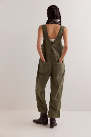 Person wearing green overalls from behind on a white background