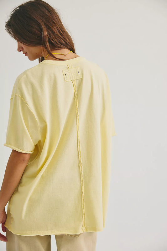 Person wearing a yellow oversized shirt on a plain background
