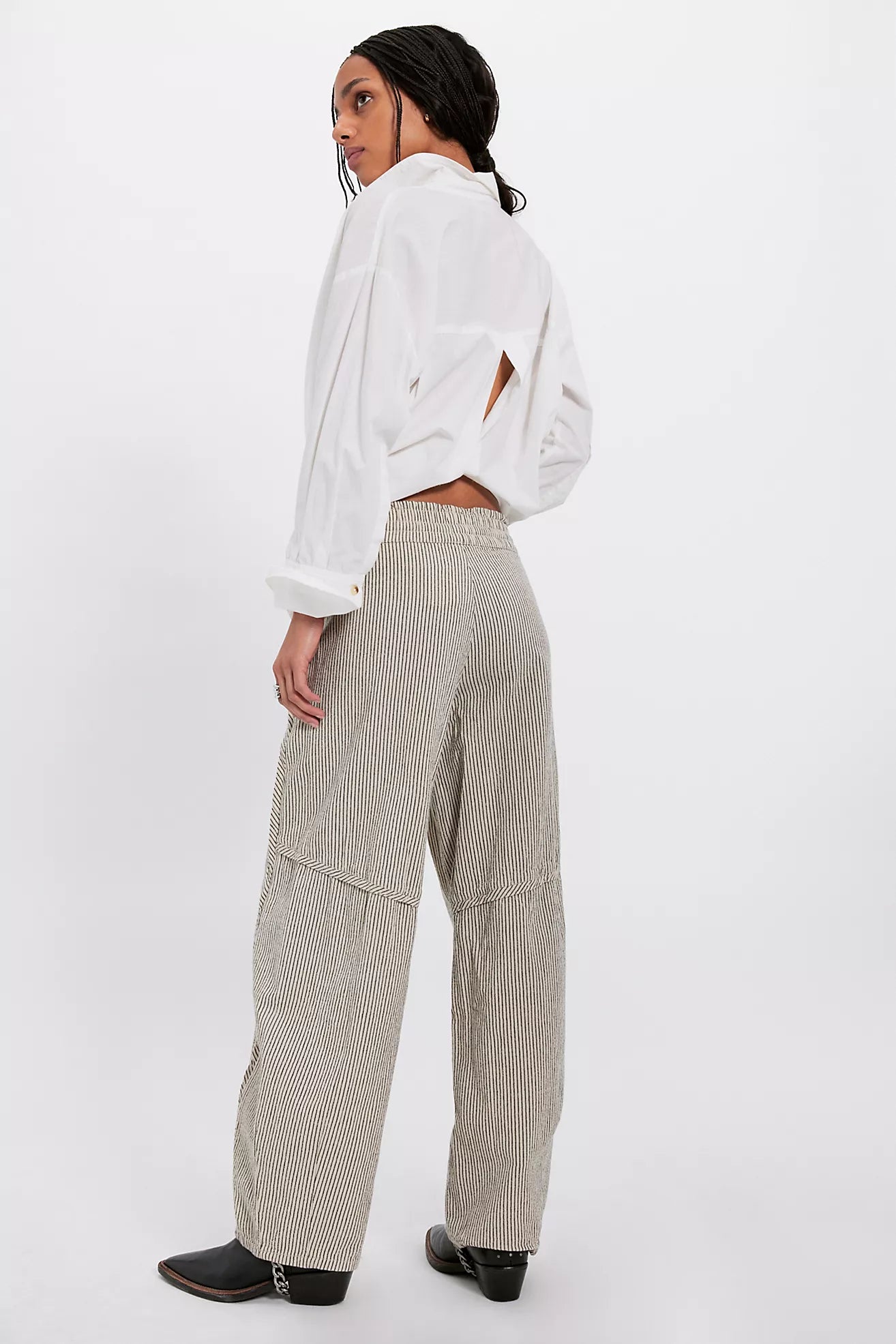 Person wearing a white jacket and beige checkered pants on a white background