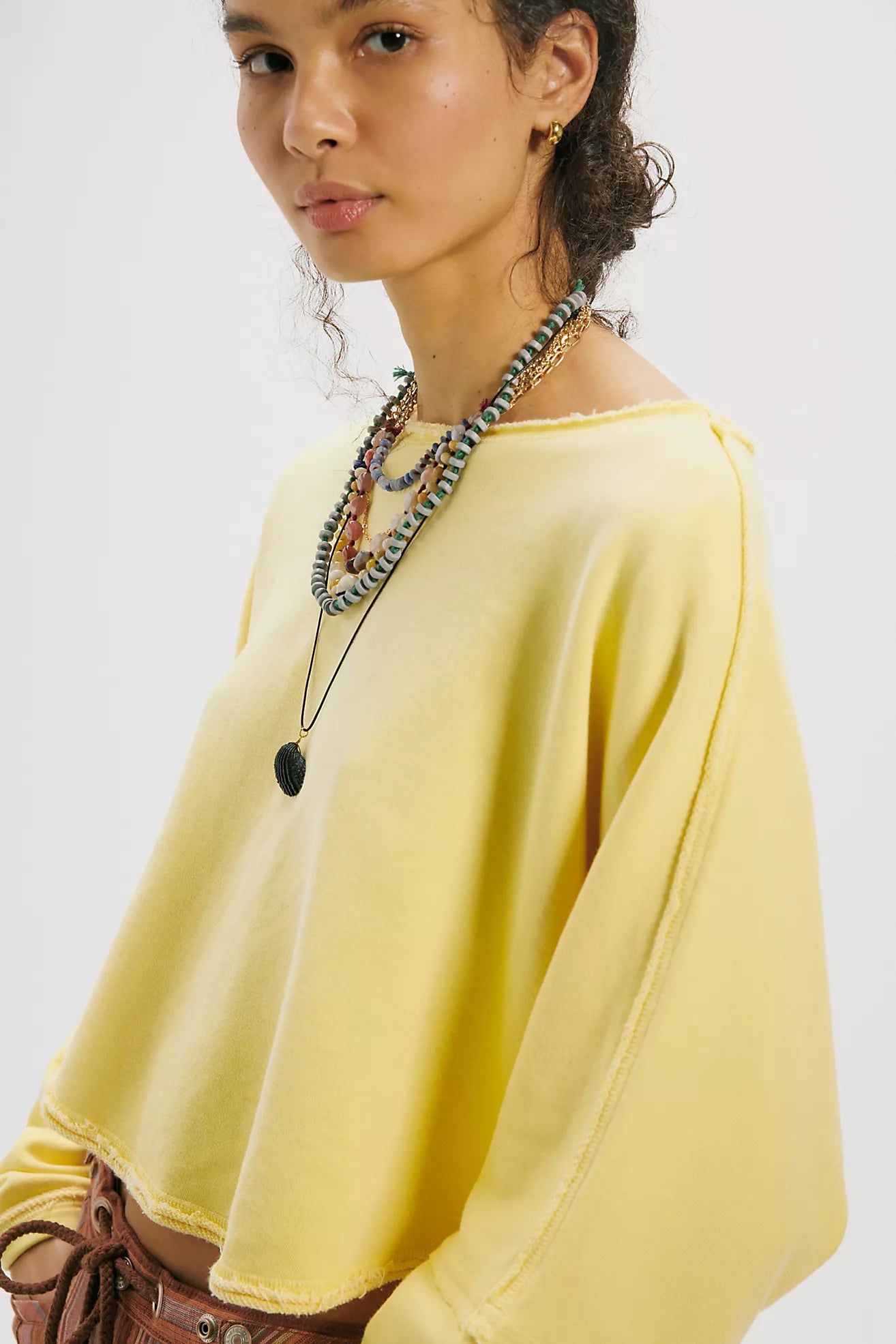 Woman wearing a yellow top with a plain background