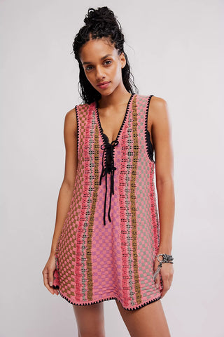 Woman wearing a patterned sleeveless dress against a plain background