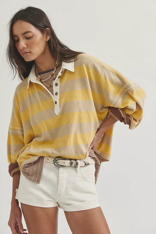 Woman wearing a yellow and beige striped shirt with white shorts on a white background