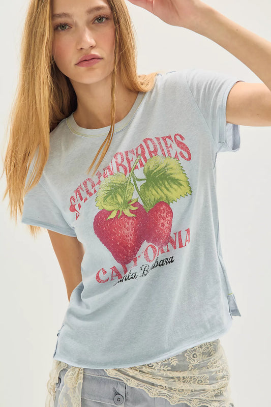Woman wearing a light blue t-shirt with strawberry and 'California' graphic design.