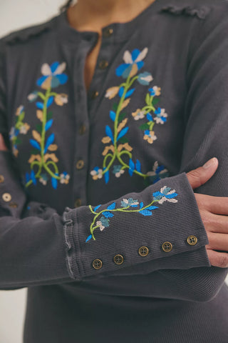 Dark gray shirt with floral embroidery on a plain background