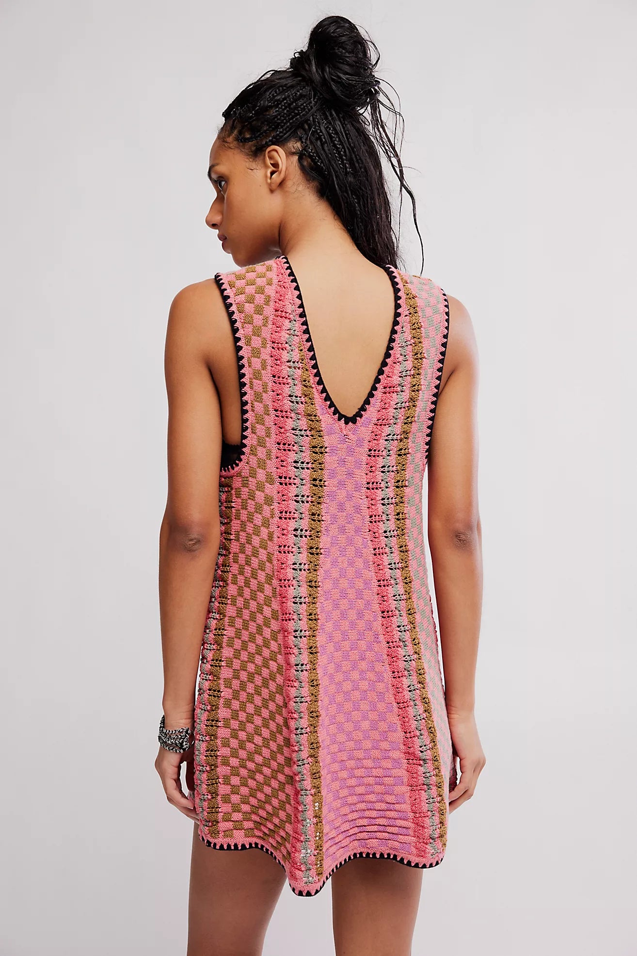 Woman wearing a pink and black patterned dress on a plain background