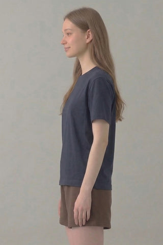 Person wearing a dark gray t-shirt and brown shorts on a plain background