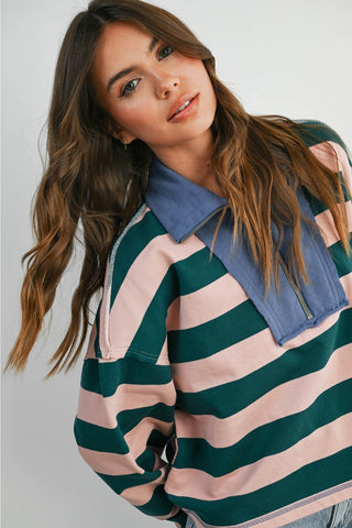 Woman wearing a striped shirt with a blue collar against a plain background