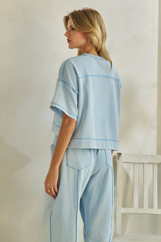 Woman wearing a light blue outfit with a white background