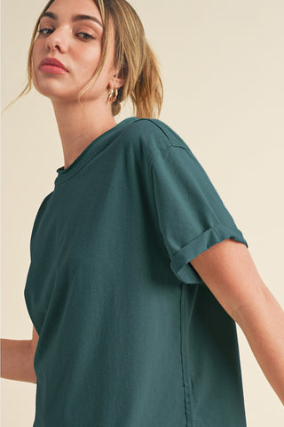 Woman wearing a teal t-shirt against a beige background