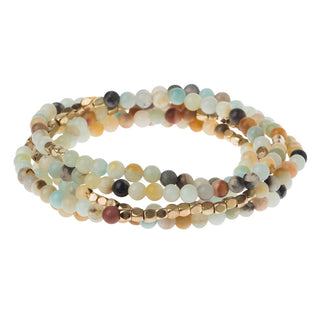 A multi-colored semi-precious stone bracelet with gold-plated brass accents, displayed as a double wrap around a wrist.