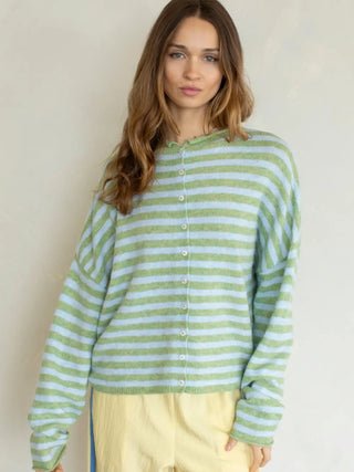 Woman wearing a green and white striped sweater against a plain background