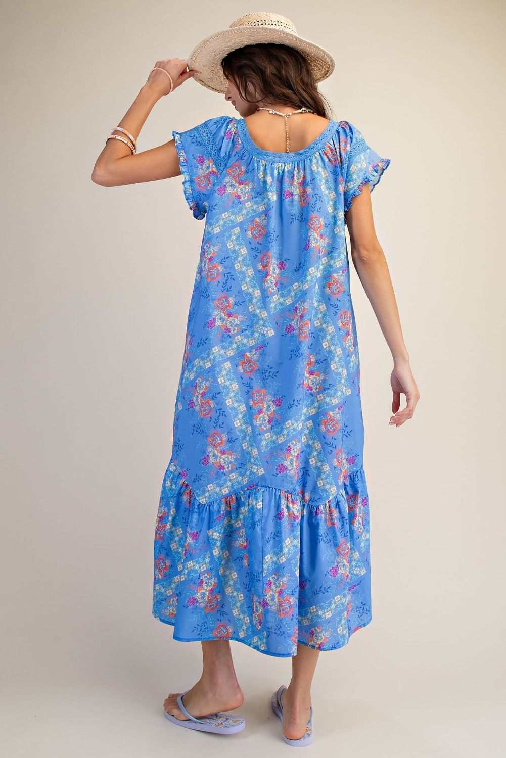 Woman wearing a blue floral dress with a plain background