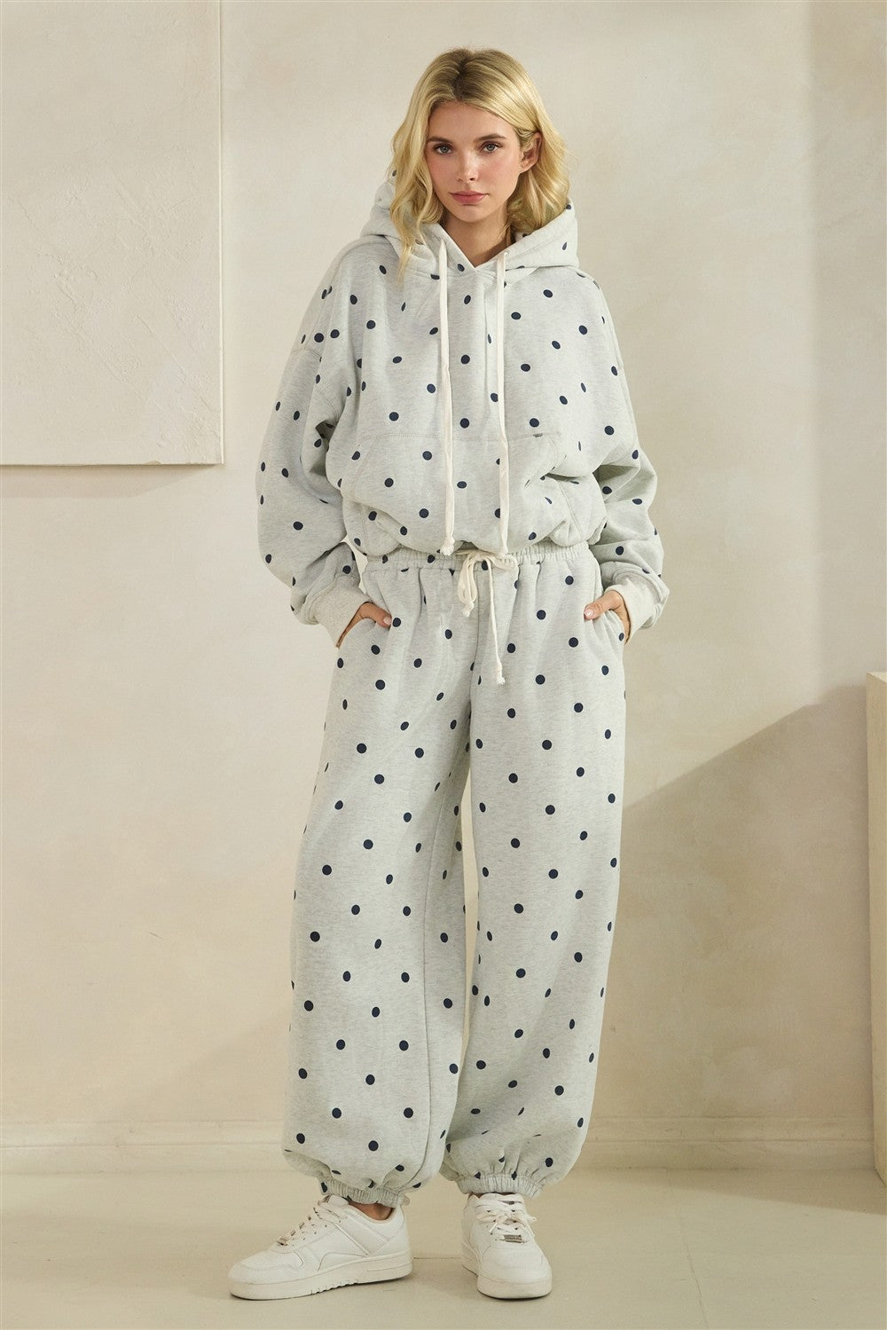 Woman wearing a polka dot tracksuit against a neutral background