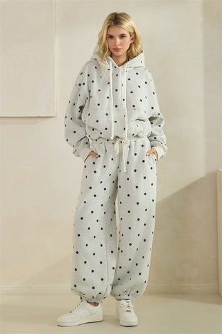 Woman wearing a polka dot tracksuit against a neutral background
