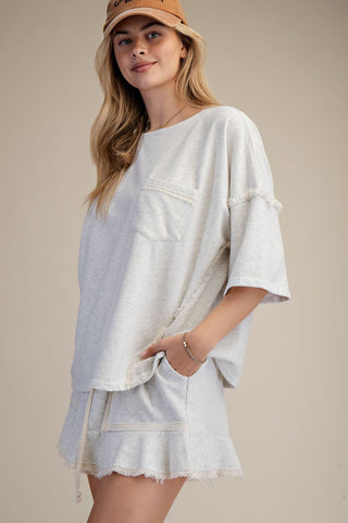 women wearing a grey matching lounge set on a neutral background. 