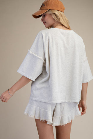 women wearing a grey matching lounge set on a neutral background. 