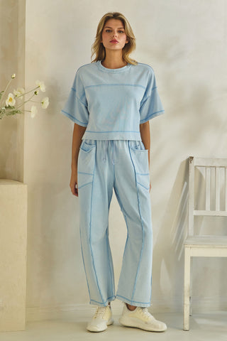 Woman wearing a light blue outfit with a plain background