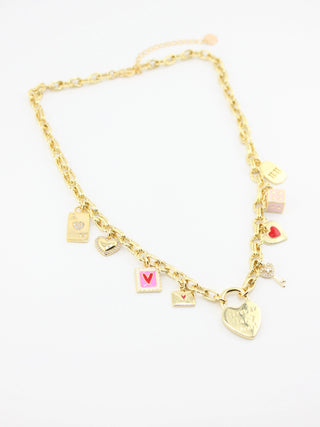 Gold necklace with various charms on a white background