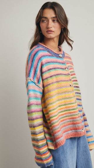 Woman wearing a colorful striped sweater against a plain background