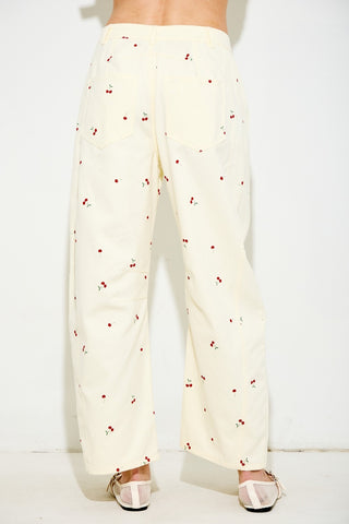 White pants with red pattern worn by a person on a white background