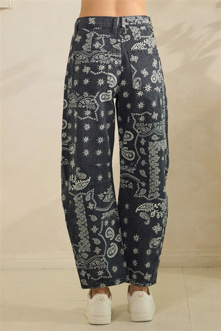 Black pants with white floral patterns on a beige background