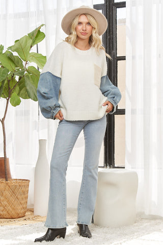 women wearing an oversized sweater with denim sleeves.