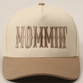 Beige and brown cap with 'MOMMIN' embroidery on a light gray background