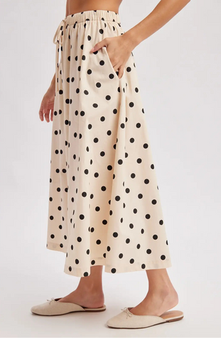 Person wearing a polka dot skirt on a white background