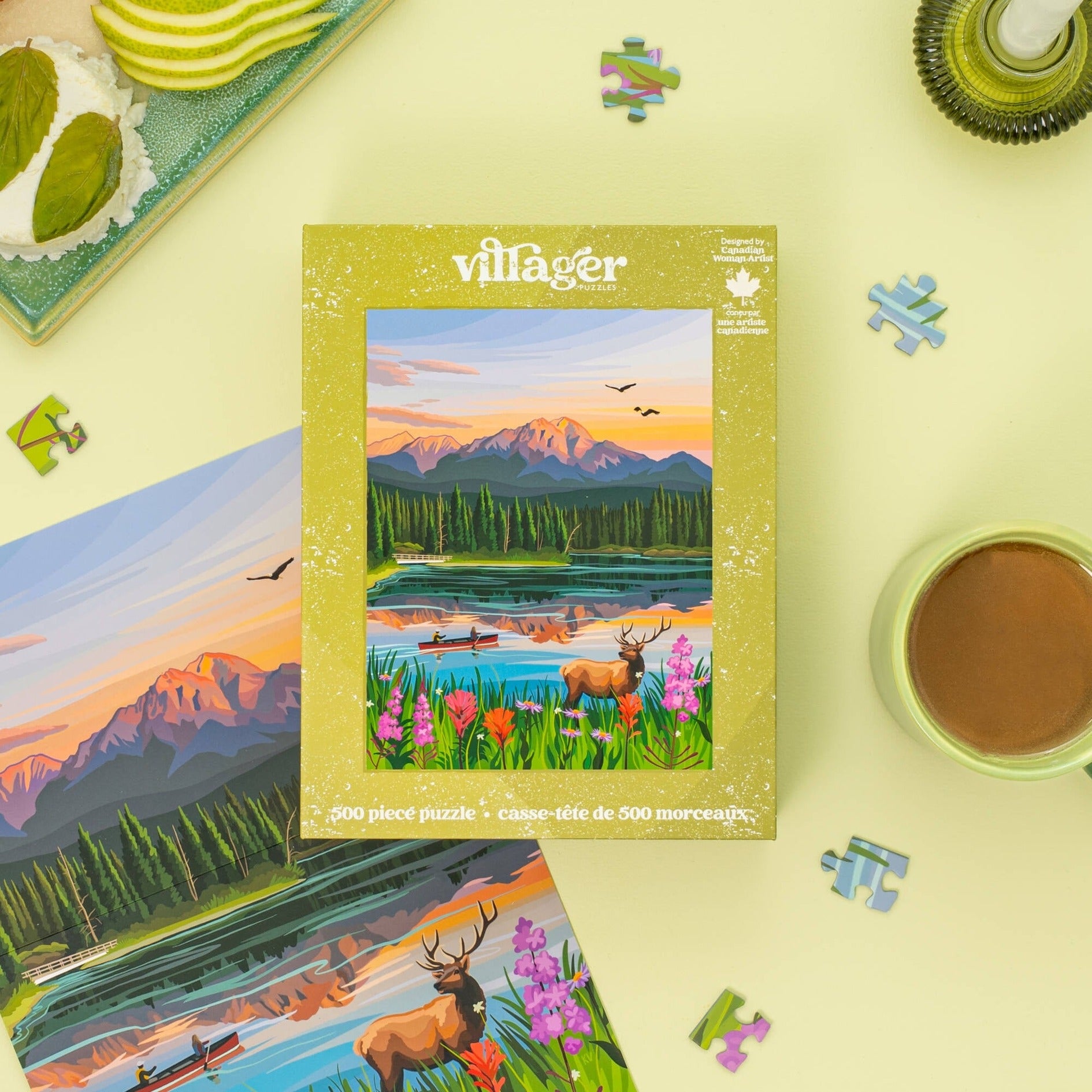 Villager puzzle box with a scenic design featuring mountains, lake, and deer on a yellow surface with puzzle pieces.
