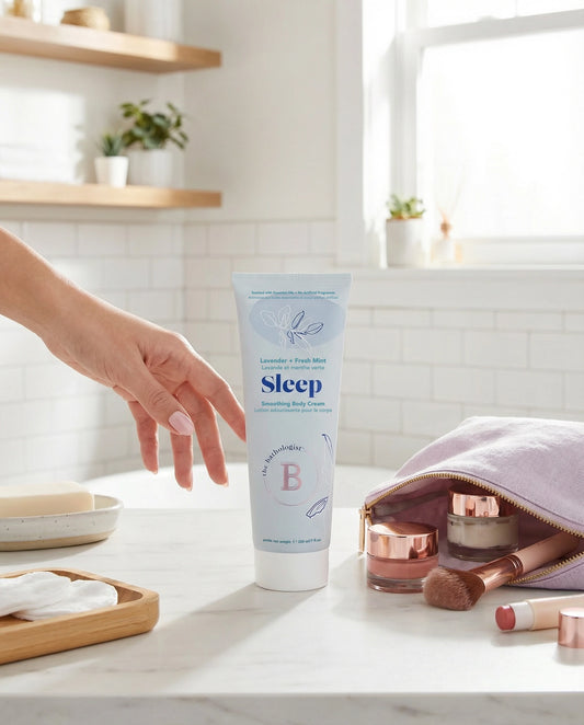 Tube of B Sleep cream on a bathroom counter with makeup items.
