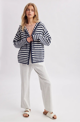 Women wearing a striped hoodie against a neutral background.