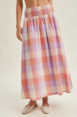 Person wearing a plaid skirt with a neutral background