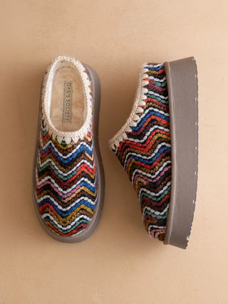 Pair of colorful zigzag patterned shoes on a beige background
