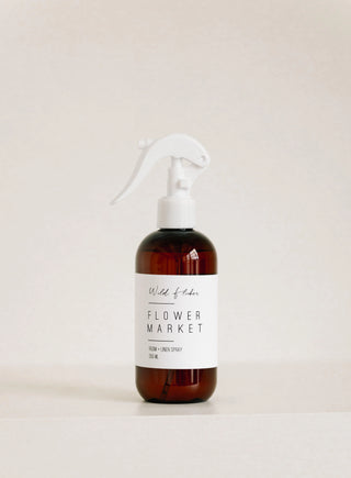 Brown  linen & room spray bottle with a white label on a light beige background