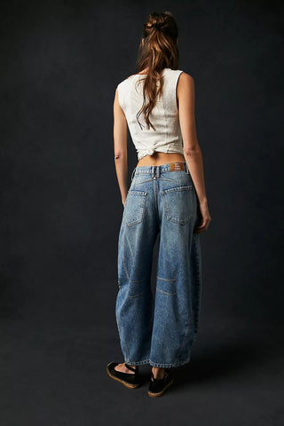 women wearing blue free people barrel jeans