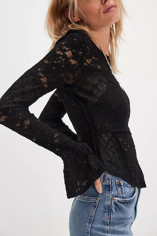 Black lace top worn by a person on a white background