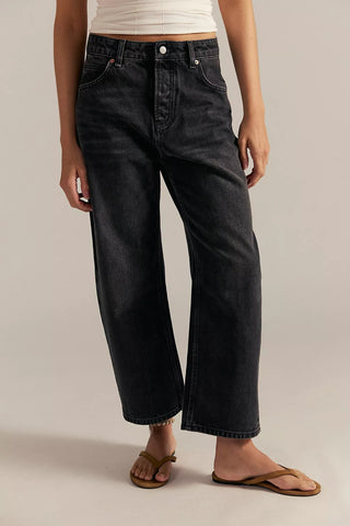 Person wearing black jeans on a plain background