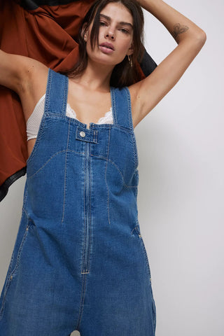 Woman wearing a blue denim dress against a plain background