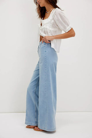 Woman wearing a white blouse and light blue jeans on a white background