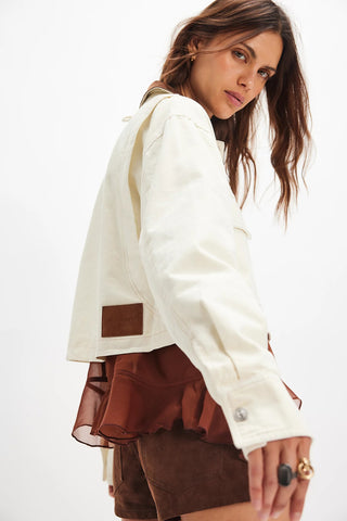 Woman wearing a white jacket over a brown outfit on a white background