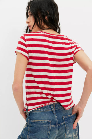 Person wearing a red and white striped shirt with blue jeans on a white background