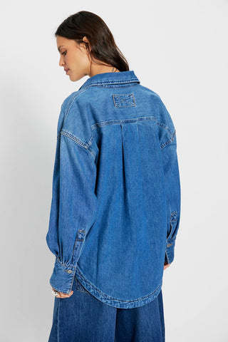 Person wearing a blue denim jacket on a white background