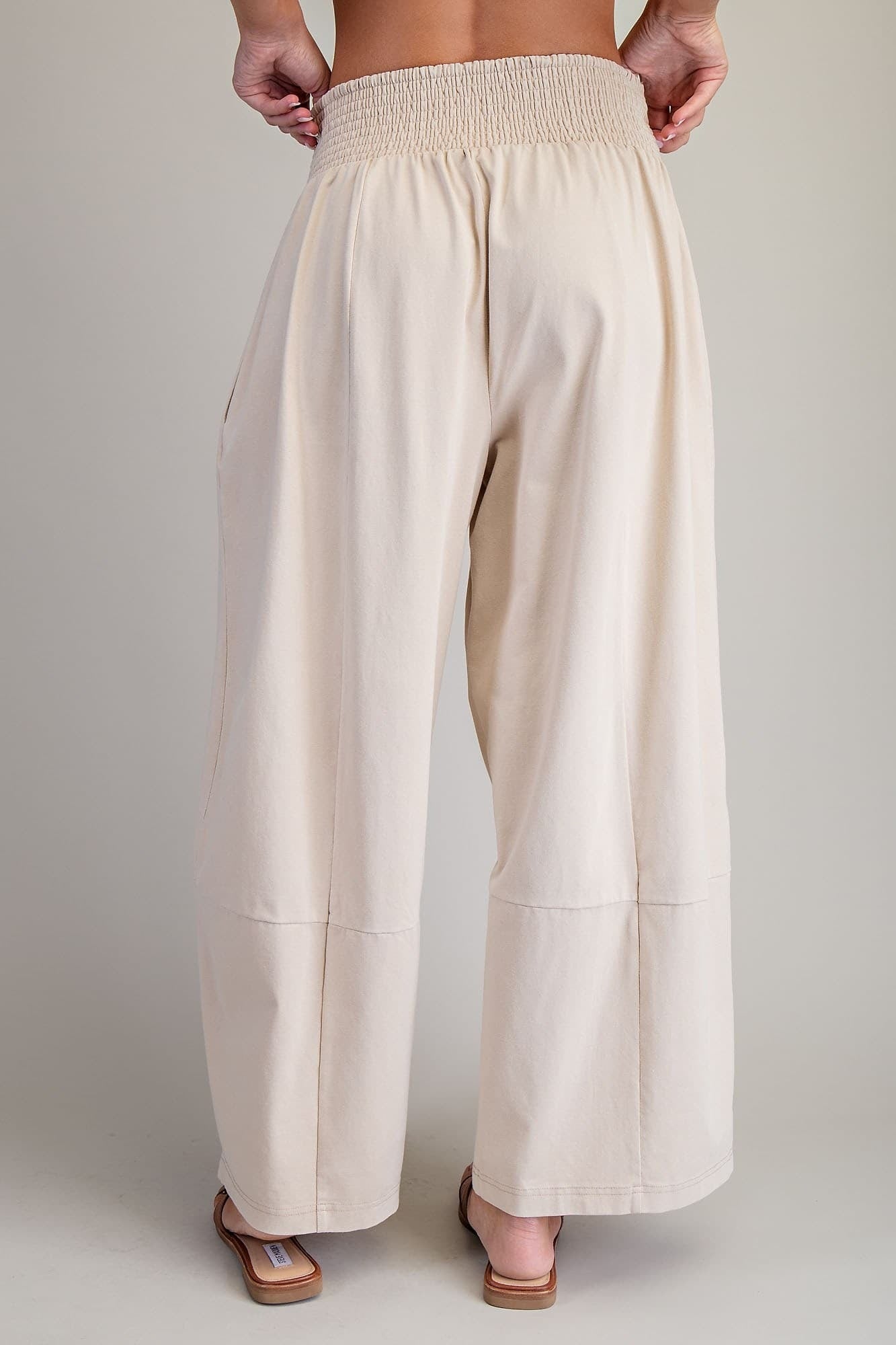 Beige wide-leg pants worn by a person on a plain background