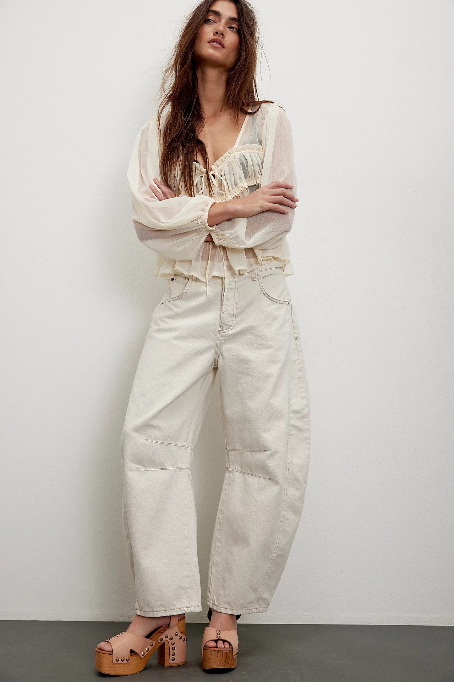 Woman wearing a white outfit with a plain background