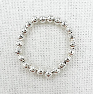 Silver beaded ring on a textured white background