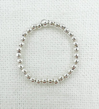 Silver beaded ring on a textured white background